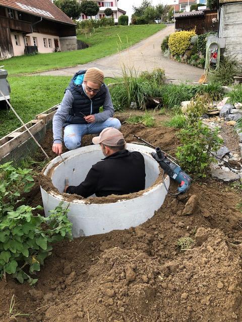 Kran beim Setzen des Betonschachtes